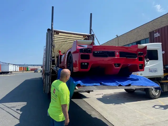 Loading a high-value car onto a specialized freight truck highlighting potential accessorial charges